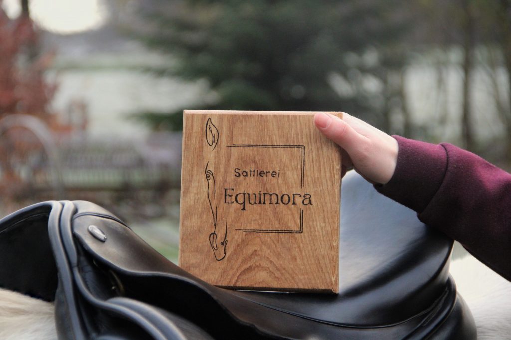 Hochwertiger Reitsattel mit Holzbrett und stilvoll platziertem Equimora-Logo.
